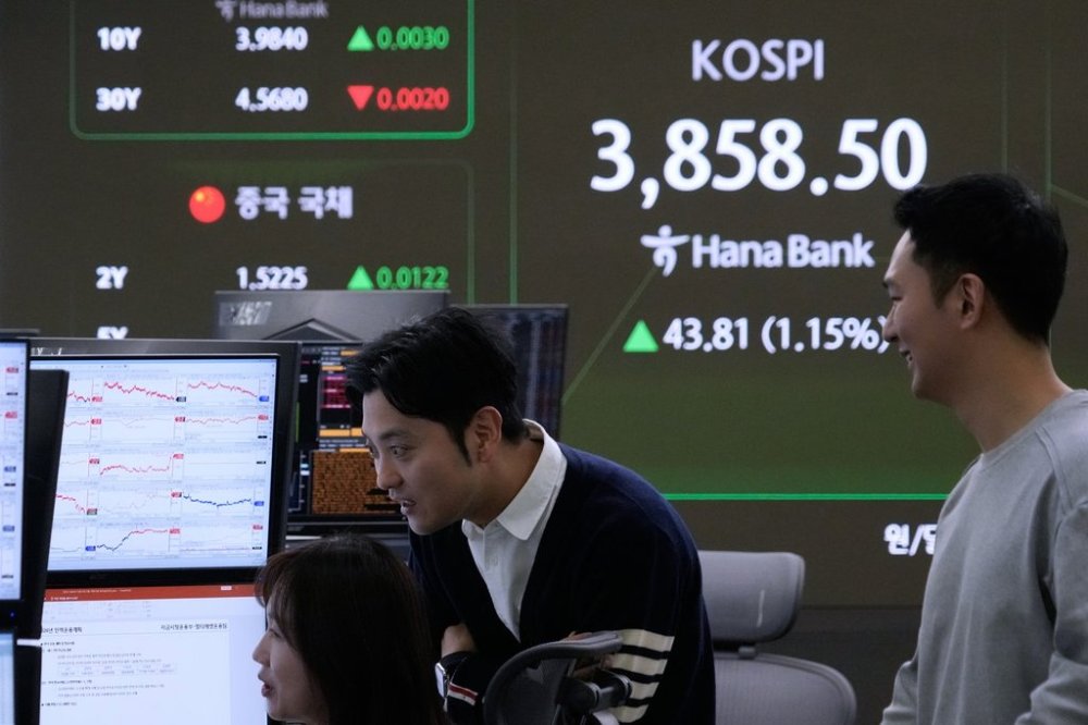 Currency traders watch monitors near a screen showing the Korea Composite Stock Price Index (KOSPI) at the foreign exchange dealing room of the Hana Bank headquarters in Seoul, South Korea, Tuesday, Oct. 21, 2025. (AP Photo/Ahn Young-joon)
