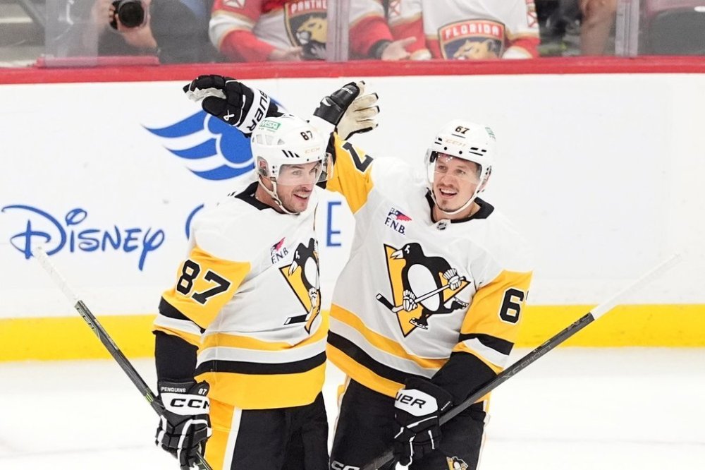Pittsburgh Penguins center Sidney Crosby (87) celebrates with right wing Rickard Rakell (67) after scoring his team's first goal during the first period of an NHL hockey game against the Florida Panthers, Thursday, Oct. 23, 2025, in Sunrise, Fla. (AP Photo/Rebecca Blackwell)