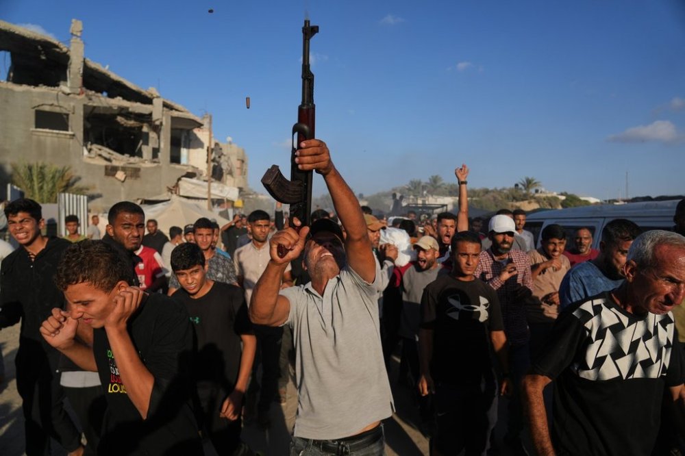 An armed man shoots in the air during the funeral of Palestinians killed by Israeli fire, in Deir al-Balah, Gaza Strip, Sunday, Oct. 19, 2025. (AP Photo/Abdel Kareem Hana)