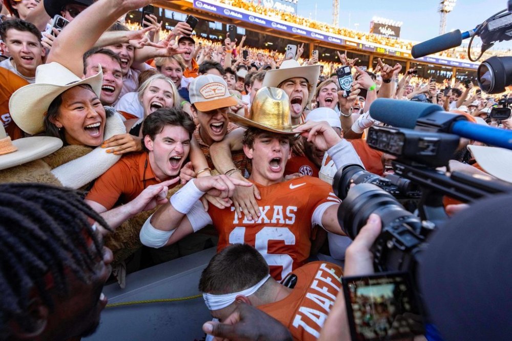 Texas quarterback Arch Manning, center, celebrates with fans after defeating Oklahoma in an NCAA college football game Saturday, Oct. 11, 2025, in Dallas. (AP Photo/Jeffrey McWhorter)