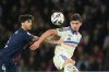 PSG's Lucas Beraldo, left, and Strasbourg's Joaquin Panichelli challenge for the ball during the French League One soccer match between Paris Saint-Germain and Strasbourg, in Paris, France, Friday, Oct. 17, 2025. (AP Photo/Christophe Ena)