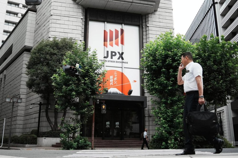 FILE - A person walks in front of Tokyo Stock Exchange building Friday, July 11, 2025, in Tokyo. (AP Photo/Eugene Hoshiko, File)