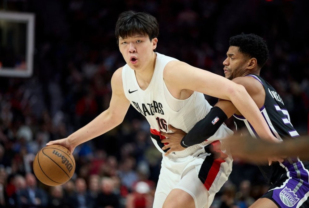 Portland Trail Blazers center Yang Hansen, left, dribbles around Sacramento Kings center Dylan Cardwell during the second half of an NBA basketball preseason game in Portland, Ore., Friday, Oct. 10, 2025. (AP Photo/Craig Mitchelldyer)