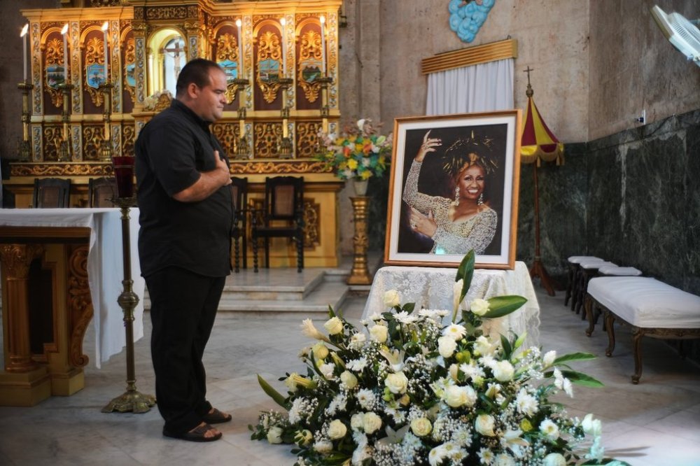 A man stands before a framed image of late singer Celia Cruz after attending a memorial Mass marking the centennial of her birth at the Virgen del Cobre or Our Lady of Charity church in Havana, Tuesday, Oct. 21, 2025. (AP Photo/Ramon Espinosa)