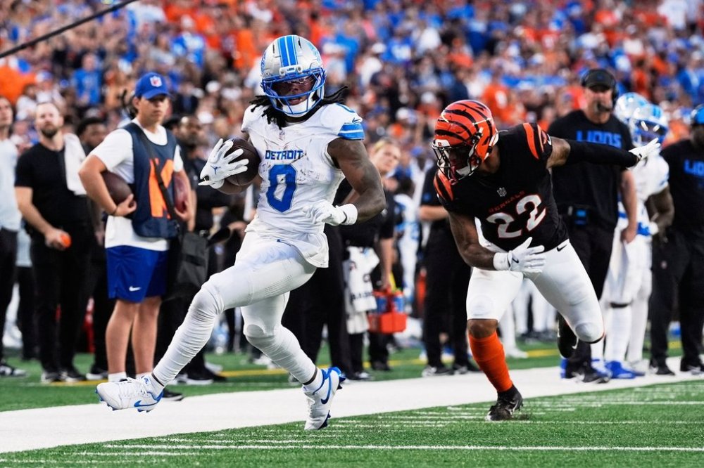 Detroit Lions running back Jahmyr Gibbs (0) runs past Cincinnati Bengals safety Geno Stone (22) during the second half of an NFL football game Sunday, Oct. 5, 2025, in Cincinnati. (AP Photo/Carolyn Kaster)