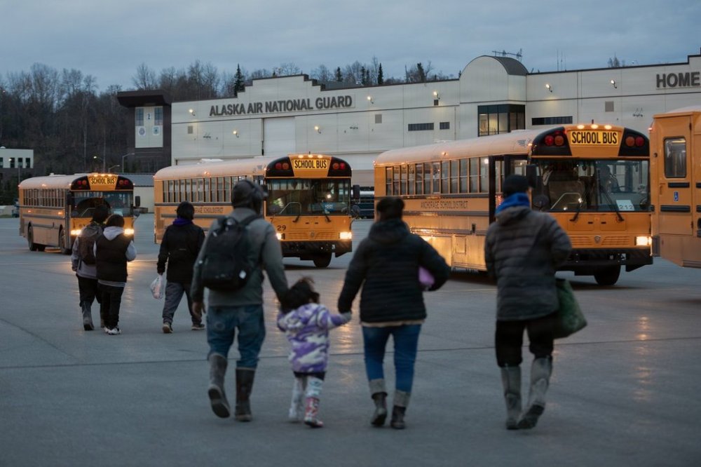 In this photo provided by the Alaska National Guard, Alaskans from West Coast communities board buses after arriving at Joint Base Elmendorf-Richardson, Alaska, Wednesday, Oct. 15, 2025. (Alejandro Pena/Alaska National Guard via AP)