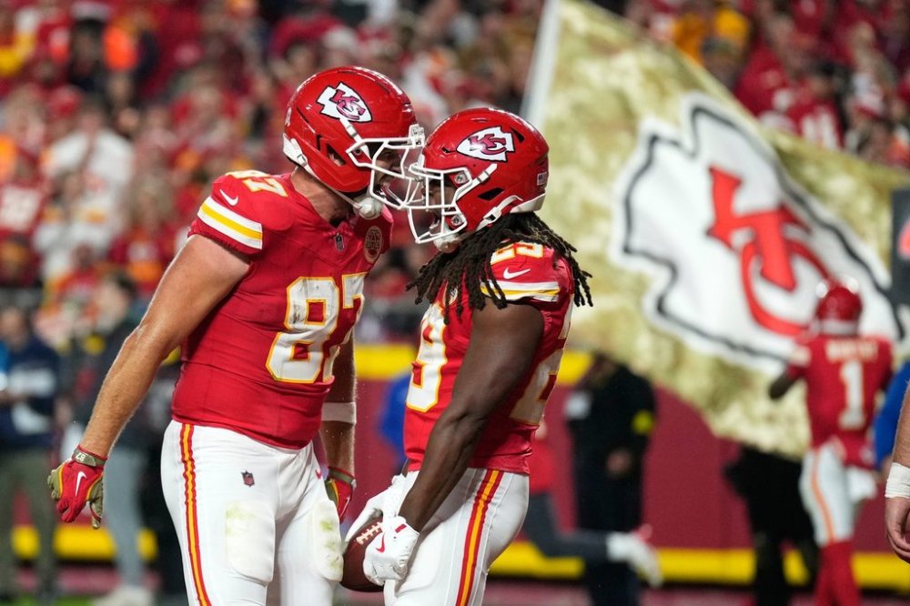 Kansas City Chiefs running back Kareem Hunt, right, is congratulated by teammate Travis Kelce (87) after catching a touchdown pass during the second half of an NFL football game against the Washington Commanders Monday, Oct. 27, 2025, in Kansas City, Mo. (AP Photo/Charlie Riedel)