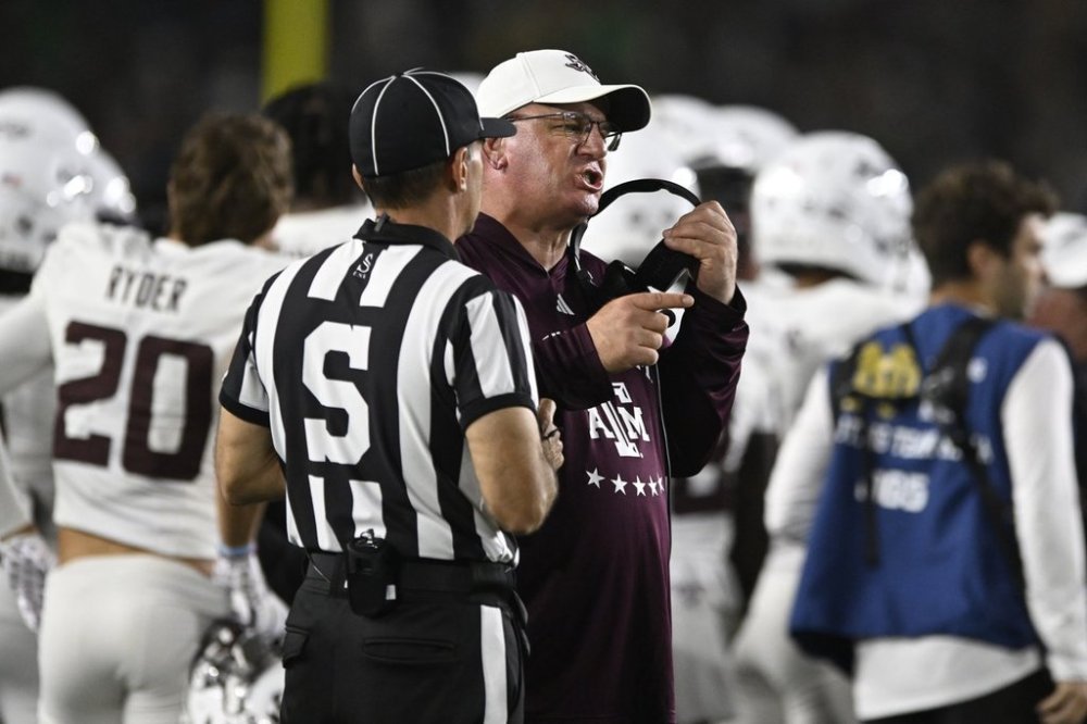 Texas A&M head coach Mike Elko, right, argues with a referee during the fourth quarter of an NCAA football game against Notre Dame, Saturday, Sept. 13, 2025, in South Bend, Ind. (AP Photo/Paul Beaty)