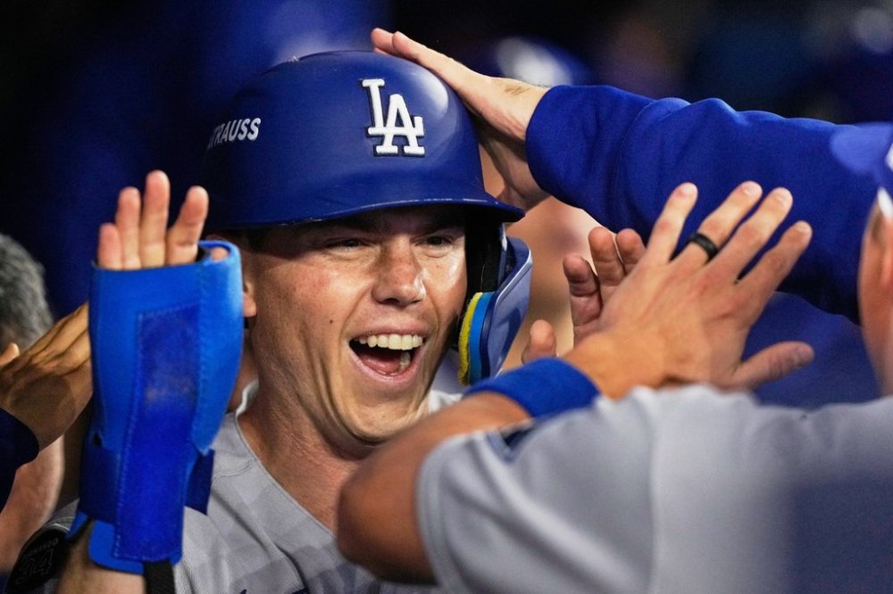 Los Angeles Dodgers' Will Smith celebrates in the dugout after scoring on a two-run single by Mookie Betts against the Toronto Blue Jays during the third inning in Game 6 of baseball's World Series, Friday, Oct. 31, 2025, in Toronto. (AP Photo/Brynn Anderson)