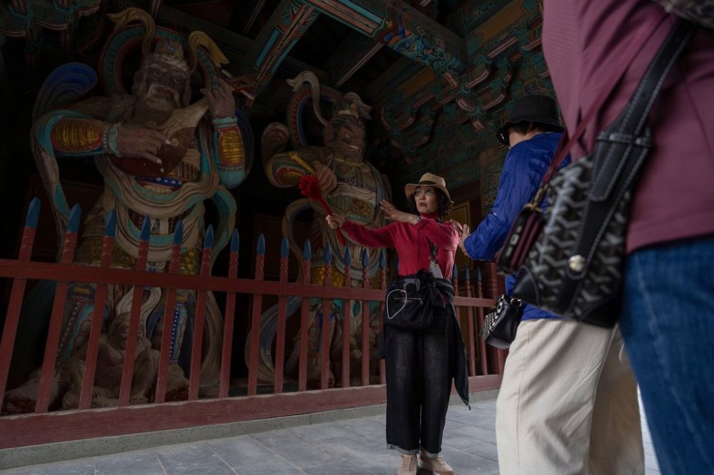 A guide briefs visitors at the Bulguksa Temple where preparations are underway ahead of events for attendees of the Asia-Pacific Economic Cooperation (APEC) summits in Gyeongju, South Korea, Thursday, Oct. 30, 2025. (AP Photo/Ng Han Guan)