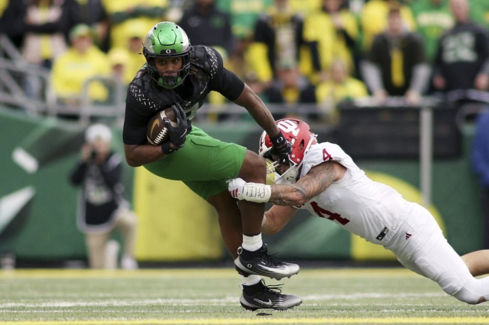 Oregon tight end Jamari Johnson (9) is tackled by Indiana linebacker Aiden Fisher (4) during the first half of an NCAA college football game, Saturday, Oct. 11, 2025, in Eugene, Ore. (AP Photo/Lydia Ely)