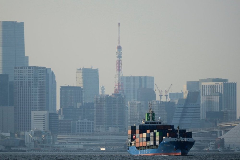 FILE - Tokyo Tower is visible amid tall buildings as a container ship leaves a cargo terminal in Tokyo, April 9, 2025. (AP Photo/Hiro Komae, File)