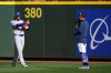 Toronto Blue Jays pitcher Kevin Gausman, left, gives a thumbs-up while greeting National Baseball Hall of Fame member and former Seattle Mariners right-fielder Ichiro Suzuki before Game 3 of baseball's American League Championship Series on Oct. 15, 2025, in Seattle. (AP Photo/Lindsey Wasson)