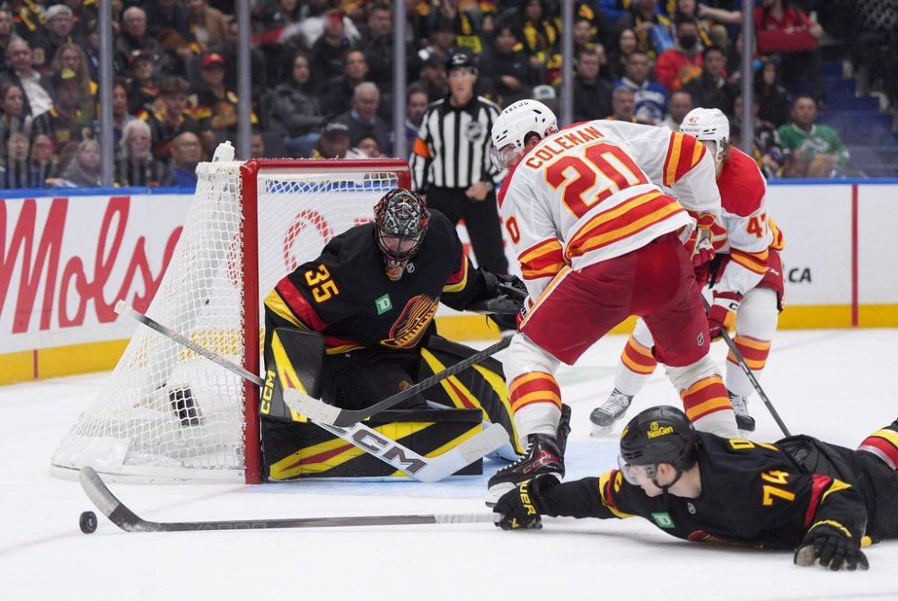 Vancouver Canucks goalie Thatcher Demko (35) watches as Jake DeBrusk (74) swats the puck away from Calgary Flames' Blake Coleman (20) during the second period of an NHL hockey game in Vancouver, on Thursday, October 9, 2025. THE CANADIAN PRESS/Darryl Dyck