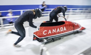 Kelsey Mitchell, left, an Olympic gold medallist in track cycling, and pilot Bianca Ribi practice starts as Mitchell tries out for the Canadian bobsled team in Calgary, Alta., Friday, Oct. 10, 2025. THE CANADIAN PRESS/Jeff McIntosh