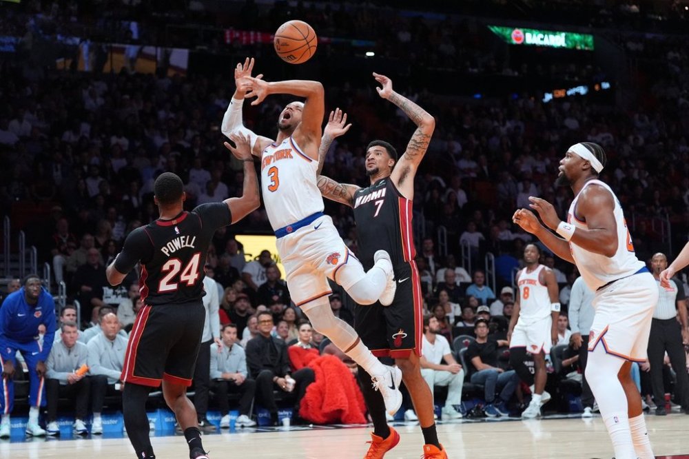 New York Knicks guard Josh Hart (3) gets fouled by Miami Heat guard Norman Powell (24) as Miami Heat center Kel'el Ware (7) looks on during the first half of an NBA basketball game, Sunday, Oct. 26, 2025, in Miami. (AP Photo/Rebecca Blackwell)