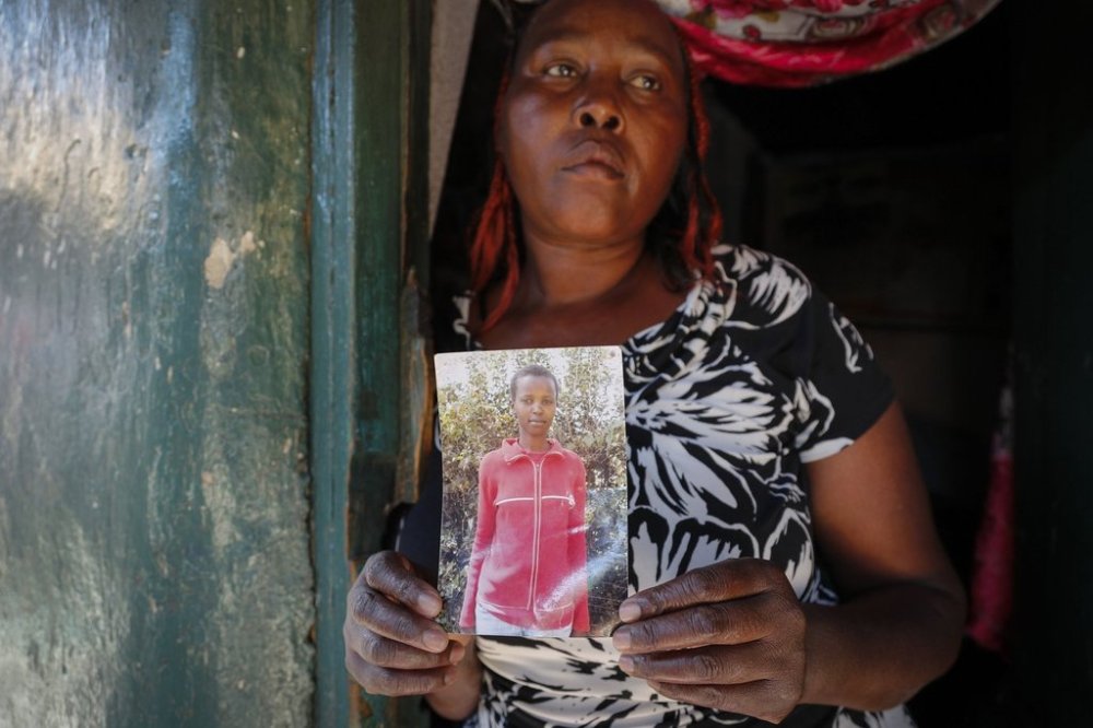 FILE - Rose Wanyua Wanjiku, elder sister to Agnes Wanjiru, 20, holds a photograph of Agnes, at Rose's house in the Majengo informal settlement in Nanyuki, Kenya, Nov. 4, 2021. (AP Photo/Brian Inganga)