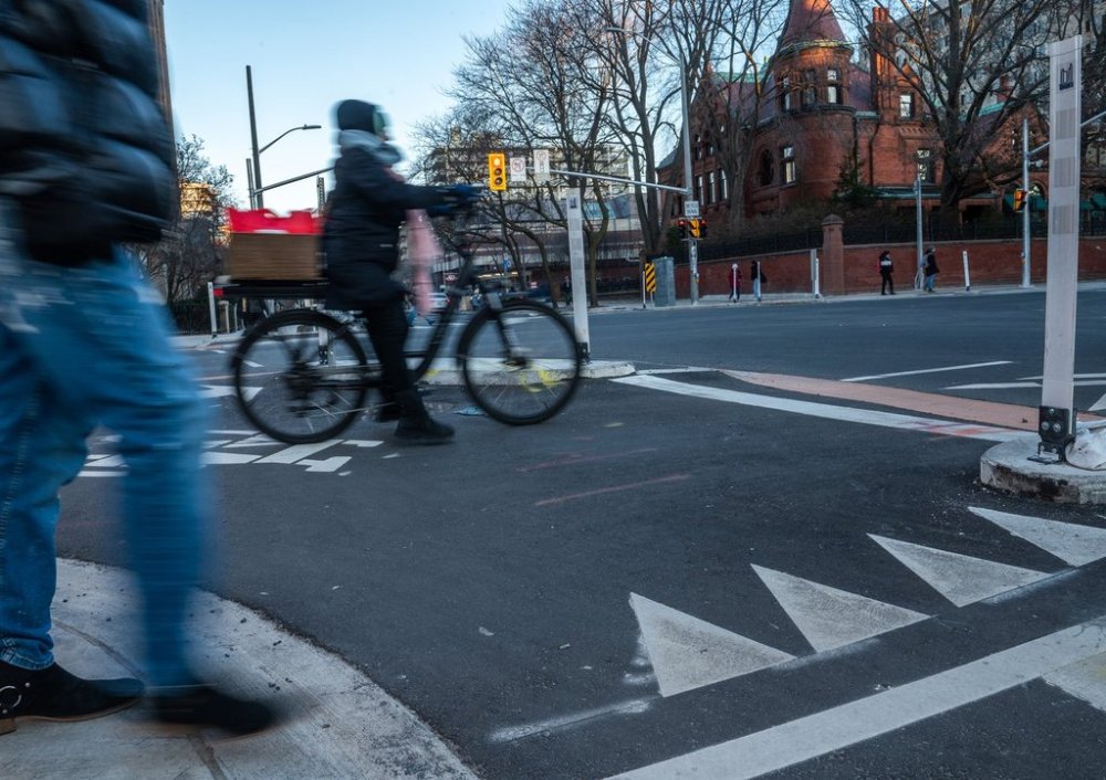 A cyclist rides in a bike lane at St. George St. And Bloor St. West in Toronto on Friday, December 13, 2024. THE CANADIAN PRESS/Laura Proctor