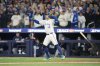 Toronto Blue Jays' George Springer (4) watches the ball after hitting a three-run home run against the Seattle Mariners during seventh inning MLB American League Championship Series game 7 baseball action in Toronto, Monday, Oct. 20, 2025. THE CANADIAN PRESS/Nathan Denette