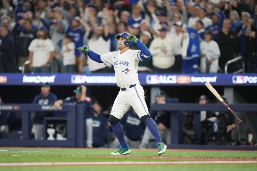 Toronto Blue Jays' George Springer (4) watches the ball after hitting a three-run home run against the Seattle Mariners during seventh inning MLB American League Championship Series game 7 baseball action in Toronto, Monday, Oct. 20, 2025. THE CANADIAN PRESS/Nathan Denette
