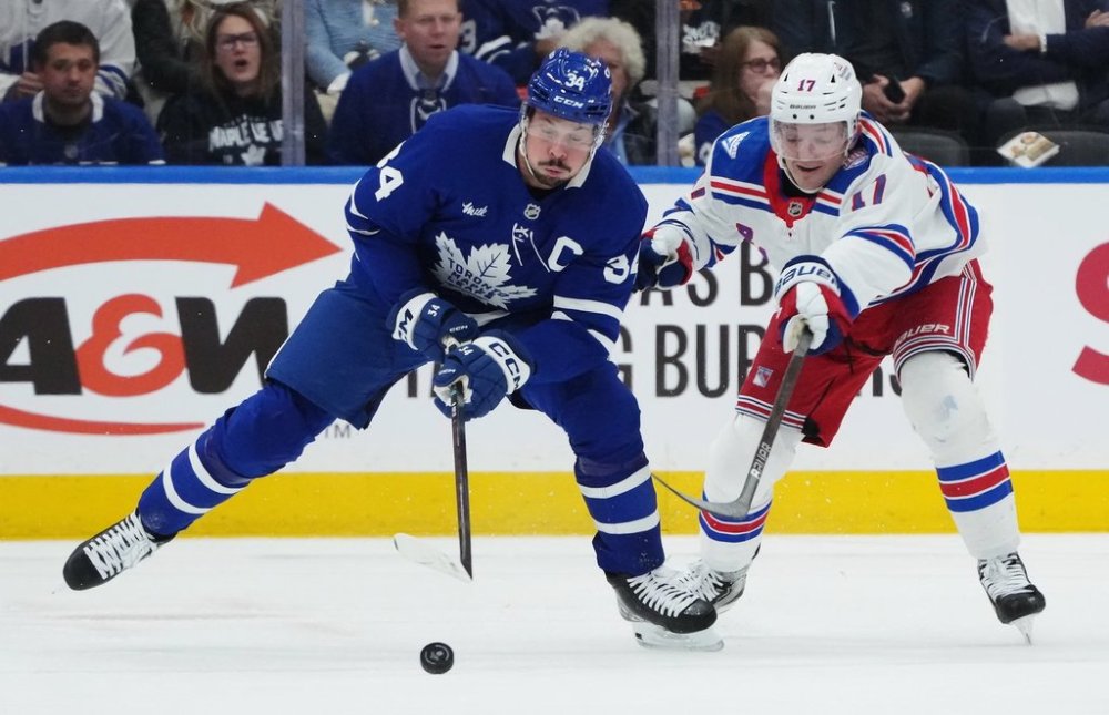 Toronto Maple Leafs' Auston Matthews (34) battles for the puck with New York Rangers' Will Borgen (17) during first period NHL hockey action in Toronto on Thursday, October 16, 2025. THE CANADIAN PRESS/Nathan Denette