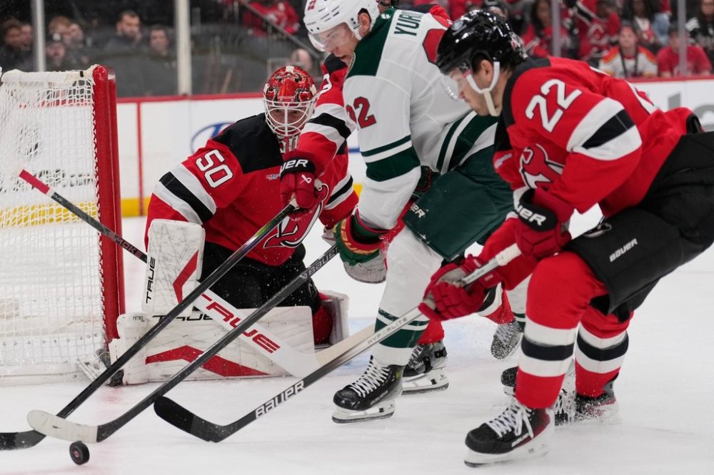 New Jersey Devils goaltender Nico Daws, left, defends the goal during the first period of an NHL hockey game against the Minnesota Wild Wednesday, Oct. 22, 2025, in Newark, N.J. (AP Photo/Seth Wenig)