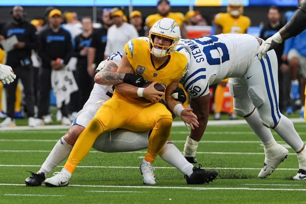 Los Angeles Chargers quarterback Justin Herbert (10) is tackled by Indianapolis Colts defensive end Laiatu Latu (97) and defensive tackle Grover Stewart (90) during the second half of an NFL football game Sunday, Oct. 19, 2025, in Inglewood, Calif. (AP Photo/Gregory Bull)