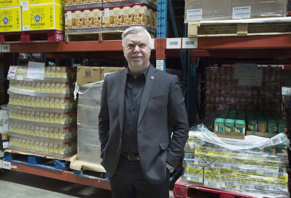 Welcome Hall Mission CEO Samuel Watts poses next to pallets of food in the warehouse of the food bank in Montreal, Tuesday, March 14, 2017. THE CANADIAN PRESS/Graham Hughes