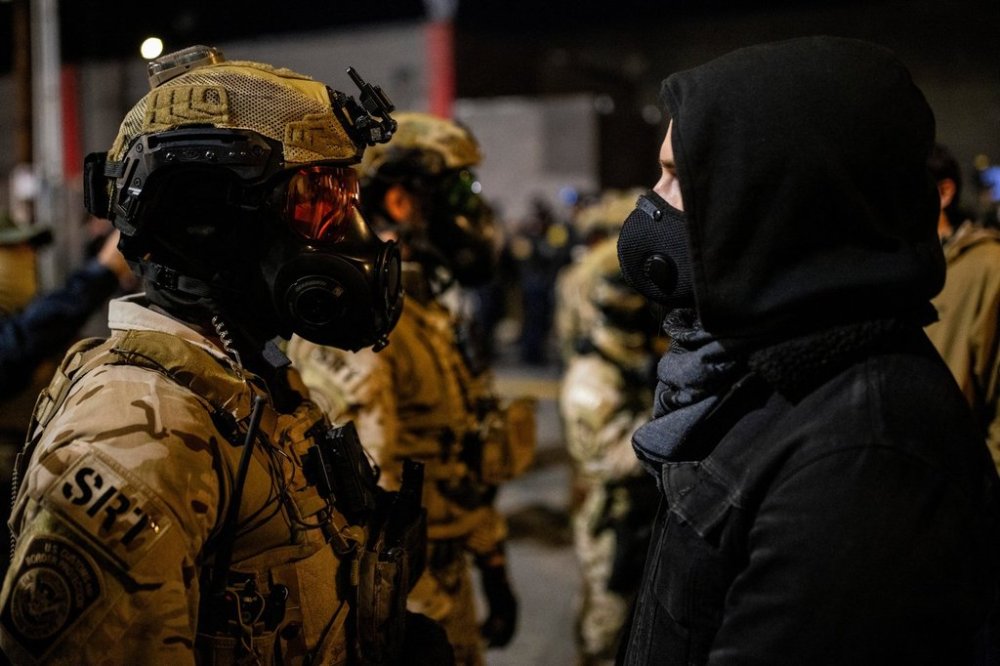 An officer with the Department of Homeland Security Special Response Team (SRT) stands against a protester outside a United States Immigration and Customs Enforcement (ICE) facility as protests against the Trump administration continue in Portland, Ore., Monday, Oct. 6, 2025. A photo of protesters dangling doughnuts in front of a line of police officers has been misrepresented online as coming out of the protests in Portland. In fact, the photo was taken in Toronto and is more than a decade old. THE CANADIAN PRESS/AP - San Francisco Chronicle, Stephen Lam