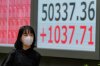 A person walks in front of an electronic stock board showing Japan's Nikkei index at a securities firm Monday, Oct. 27, 2025, in Tokyo. (AP Photo/Eugene Hoshiko)