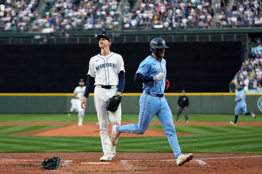 Toronto Blue Jays' Nathan Lukes scores on a wild pitch by Seattle Mariners pitcher George Kirby, left, during the third inning in Game 3 of baseball's American League Championship Series, Wednesday, Oct. 15, 2025, in Seattle. (AP Photo/David J. Phillip)
