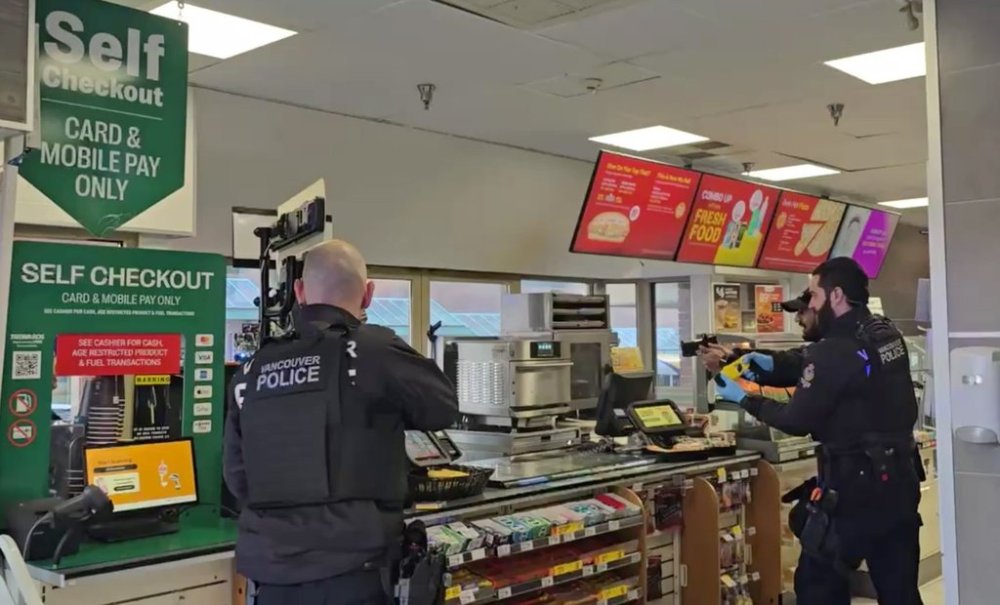 Vancouver Police officers are shown aiming their guns over the counter of a convenience store in Vancouver on Wednesday, Dec. 4, 2024, in this still taken from handout video. THE CANADIAN PRESS/HO - Mainul Islam