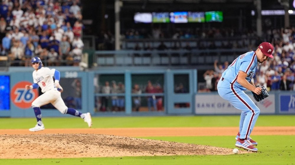 Philadelphia Phillies pitcher Orion Kerkering looks down at a ground ball from Los Angeles Dodgers' Andy Pages before committing a throwing error to home platev and allowing the game-winning run to score during the eleventh inning in Game 4 of baseball's National League Division Series against the Los Angeles Dodgers, Thursday, Oct. 9, 2025, in Los Angeles. (AP Photo/Mark J. Terrill)