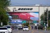 FILE - Traffic drives in view of a Boeing Co. production plant, where images of jets decorate the hangar doors on April 23, 2021, in Everett, Wash. (AP Photo/Elaine Thompson, File)