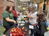 Annik Stevens, second from right, speaks to staff at Nourish Nova Scotia's Nourish Fest event, as her daughter Amy, right, looks on at the Halifax Brewery Market, in Halifax, on Sunday, Oct. 19, 2025. THE CANADIAN PRESS/Emily Baron Cadloff