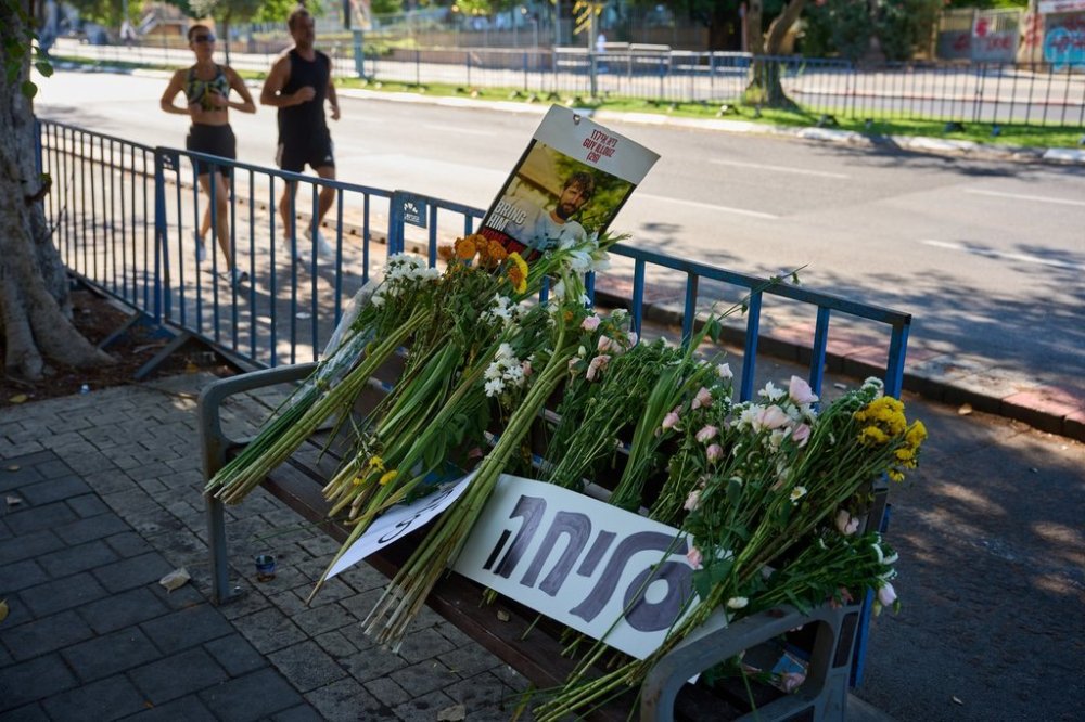 Flowers and a sign written in Hebrew reads