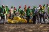 FILE - Workers collect debris on March 12, 2019 at the scene where an Ethiopian Airlines Boeing 737 Max 8 crashed shortly after takeoff, killing all 157 on board, near Bishoftu, or Debre Zeit, south of Addis Ababa, in Ethiopia. (AP Photo/Mulugeta Ayene, File)