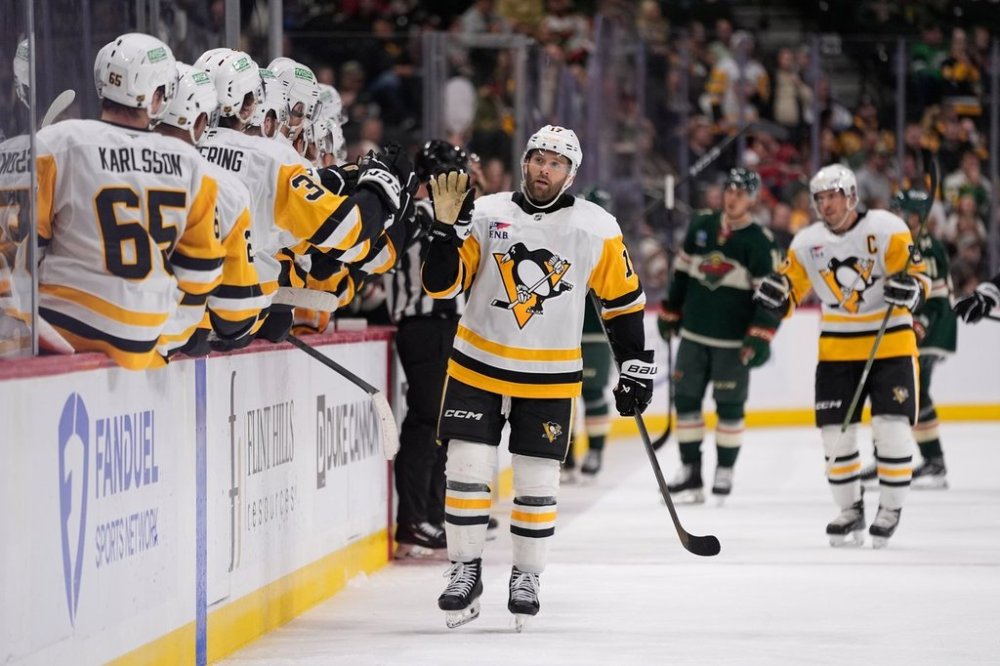 Pittsburgh Penguins right wing Bryan Rust (17) celebrates with teammates after scoring a goal during the third period of an NHL hockey game against the Minnesota Wild, Thursday, Oct. 30, 2025, in St. Paul, Minn. (AP Photo/Abbie Parr)