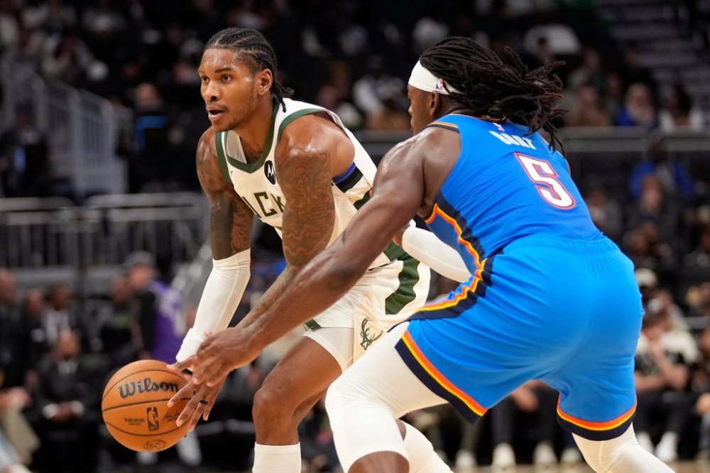 Milwaukee Bucks guard Kevin Porter Jr., left, handles the ball against Oklahoma City Thunder guard Luguentz Dort (5) during the first half of a preseason NBA basketball game Tuesday, Oct. 14, 2025, in Milwaukee. (AP Photo/Kayla Wolf)