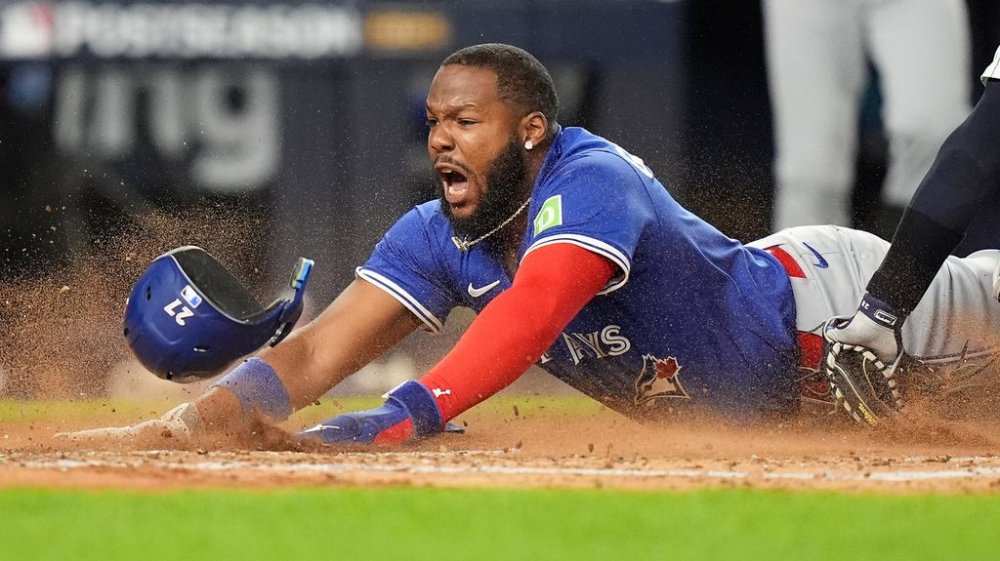 Toronto Blue Jays Vladimir Guerrero Jr. dives into home plate to score against the New York Yankees during the third inning of Game 3 of baseball's American League Division Series, Tuesday, Oct. 7, 2025, in New York. (AP Photo/Frank Franklin II)