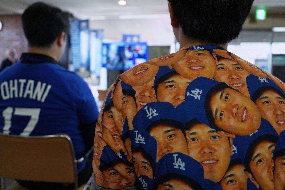 A man wears a shirt featuring Shohei Ohtani of the Los Angeles Dodgers as he watches Game 6 of the baseball World Series between the Los Angeles Dodgers and the Toronto Blue Jays during a public viewing event in Oshu, northeastern Japan, the hometown of Ohtani, Saturday, Nov. 1, 2025. (AP Photo/Koji Ueda)