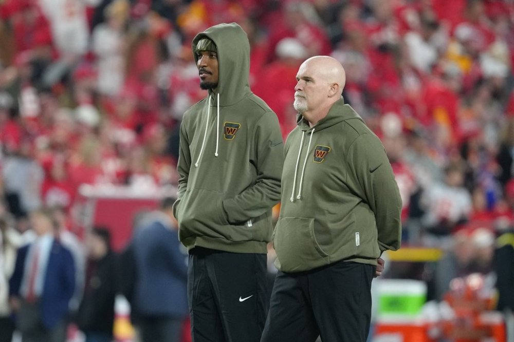 Washington Commanders head coach Dan Quinn, right, stands with quarterback Jayden Daniels before an NFL football game against the Kansas City Chiefs Monday, Oct. 27, 2025, in Kansas City, Mo. (AP Photo/Ed Zurga)
