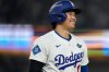 Los Angeles Dodgers' Shohei Ohtani smiles after a walk during the ninth inning in Game 3 of baseball's World Series against the Toronto Blue Jays, Monday, Oct. 27, 2025, in Los Angeles. (AP Photo/Ashley Landis)