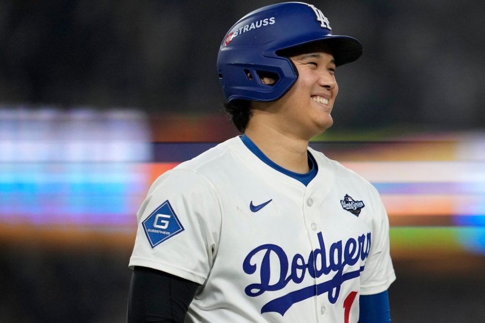Los Angeles Dodgers' Shohei Ohtani smiles after a walk during the ninth inning in Game 3 of baseball's World Series against the Toronto Blue Jays, Monday, Oct. 27, 2025, in Los Angeles. (AP Photo/Ashley Landis)