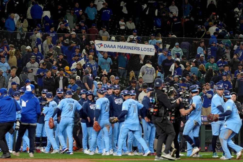 The Toronto Blue Jays celebrate after Game 3 of baseball's American League Championship Series against the Seattle Mariners, Wednesday, Oct. 15, 2025, in Seattle. (AP Photo/Lindsey Wasson)