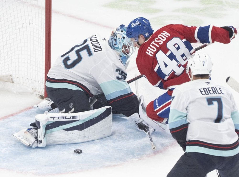 Seattle Kraken goaltender Joey Daccord (35) makes a save against Montreal Canadiens' Lane Hutson (48) during first period NHL hockey action in Montreal on Tuesday, Oct. 14, 2025. THE CANADIAN PRESS/Christinne Muschi