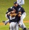 Florida shortstop Alex Gonzalez, right, leaps on teammates Ivan Rodriguez, centre, and Derek Lee, left, after the Marlins defeated the Yankees 2-0 to win the World Series at Yankee Stadium in New York on Oct. 25, 2003. (AP Photo/Bill Kostroun)