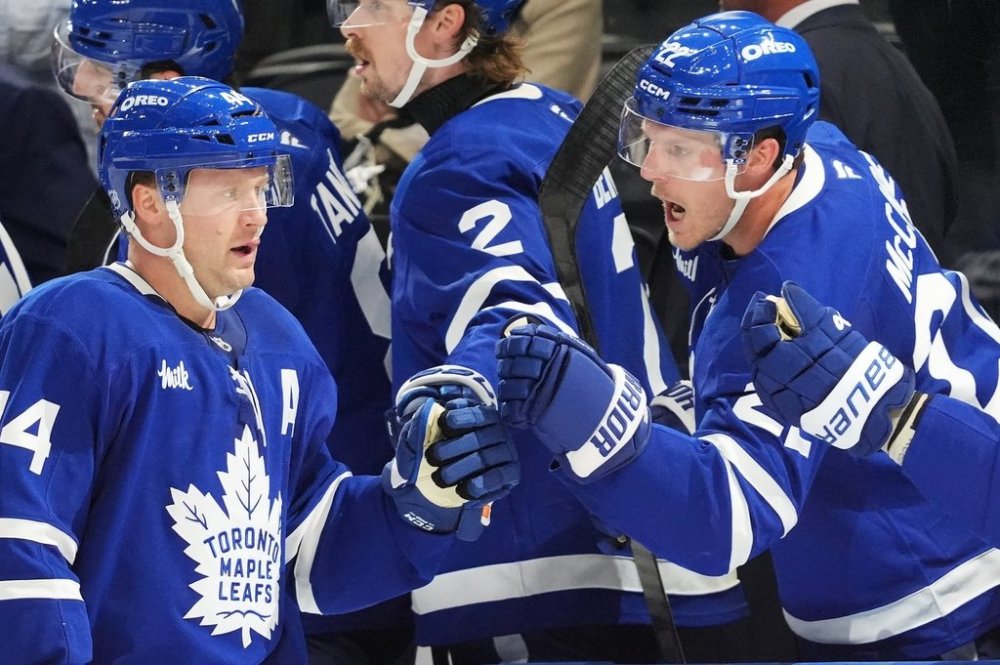 Toronto Maple Leafs' Morgan Rielly (left) celebrates his goal against the Montreal Canadiens with Jake McCabe (22) during third period NHL hockey action in Toronto on Wednesday, Oct. 8, 2025. THE CANADIAN PRESS/Frank Gunn