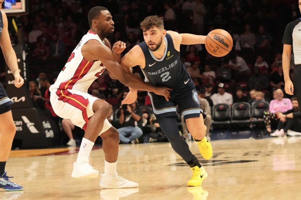 Memphis Grizzlies guard Ty Jerome (2) dribbles the ball as Miami Heat forward Andrew Wiggins (22) defends during the first half of an NBA preseason basketball game, Friday, Oct. 17, 2025, in Miami. (AP Photo/Marta Lavandier)