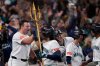 Seattle Mariners' Eugenio Suárez holds the trident after hitting a grand slam home run during the eighth inning in Game 5 of baseball's American League Championship Series against the Toronto Blue Jays, Friday, Oct. 17, 2025, in Seattle. (AP Photo/Lindsey Wasson)
